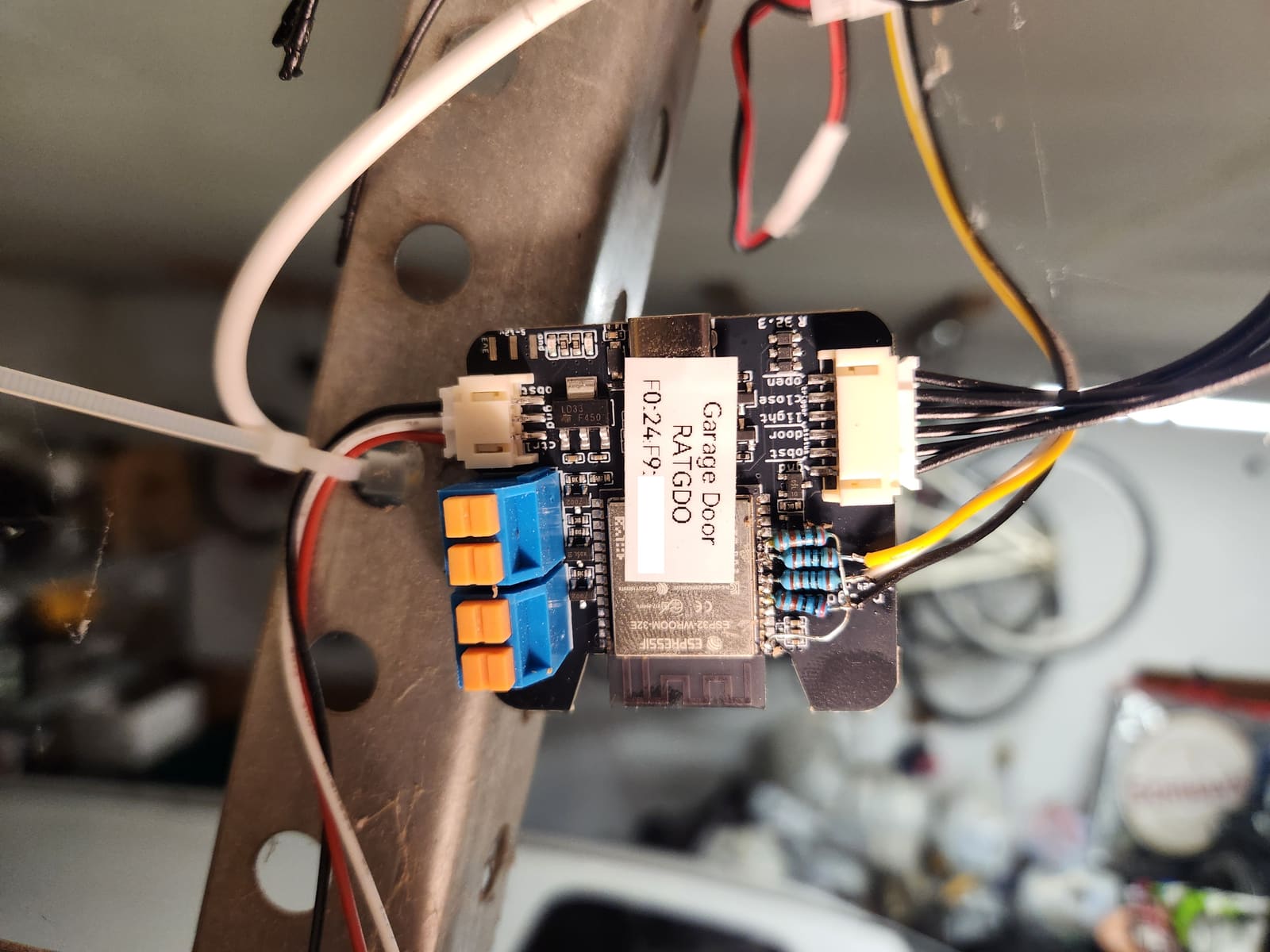 RATGDO board wired with resistor-divider level shifting for the Wiegand keypad, mounted in the garage door opener housing